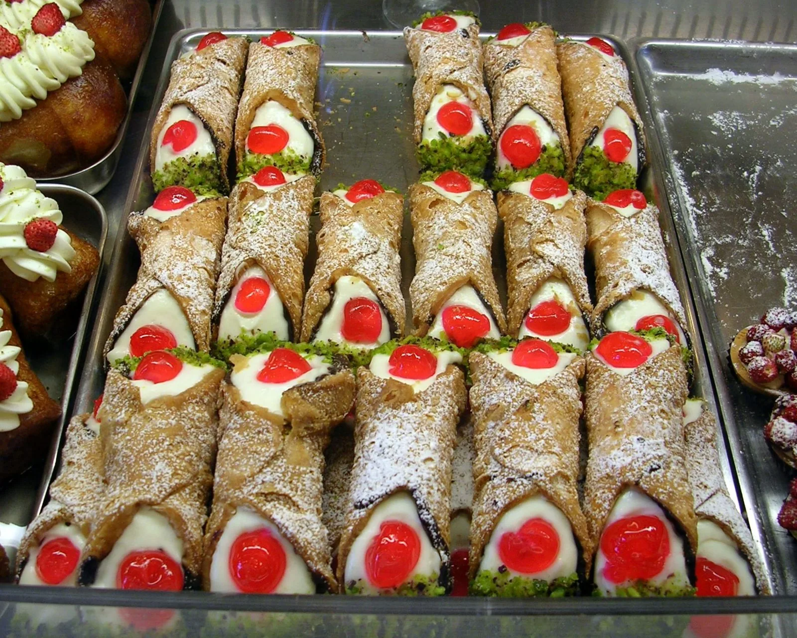 Vassoio di cannoli siciliani ripieni di ricotta, con granella di pistacchio e ciliegie candite