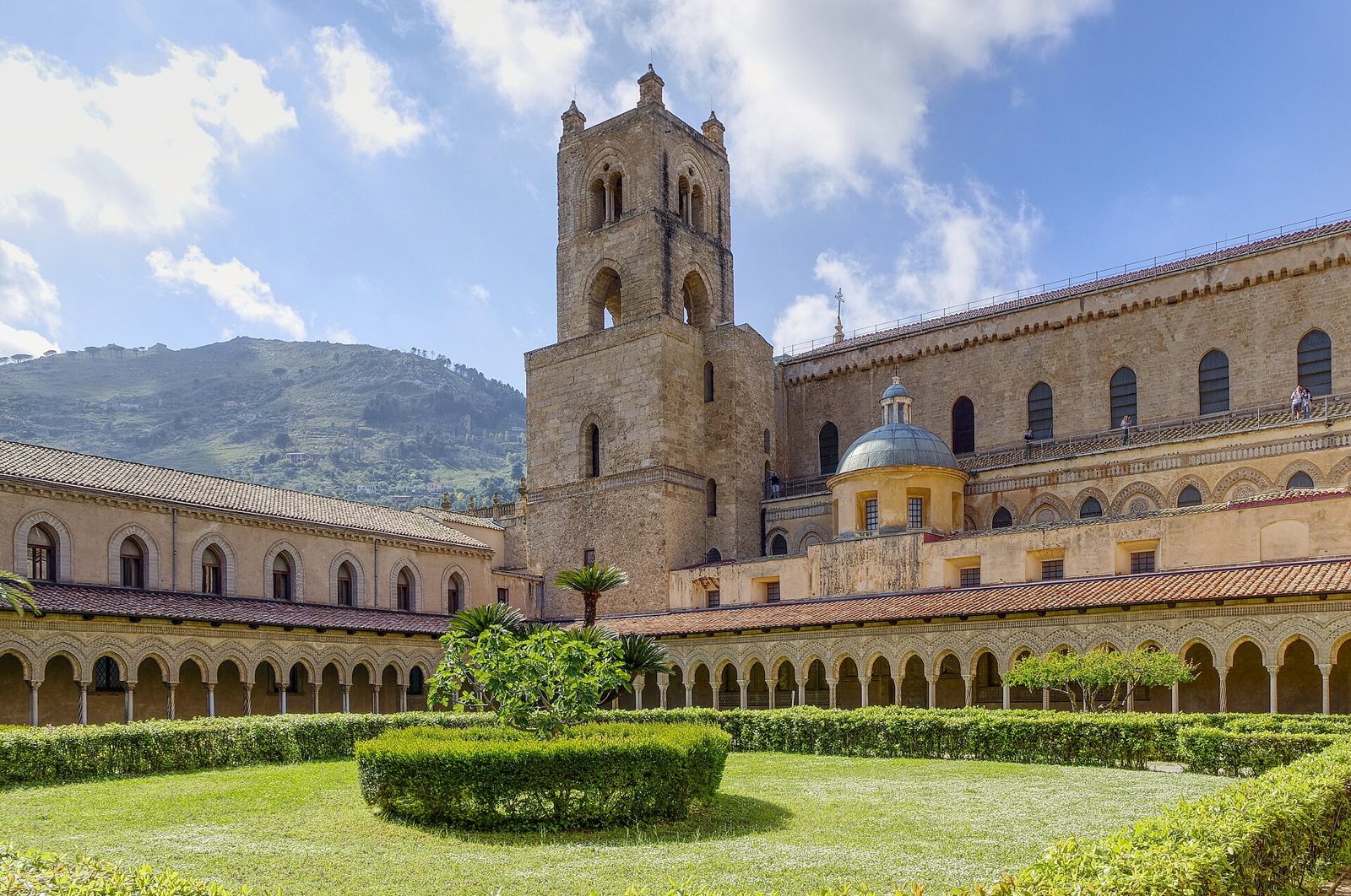 Il chiostro benedettino di Monreale con il porticato ad archi, il campanile e il fianco del Duomo