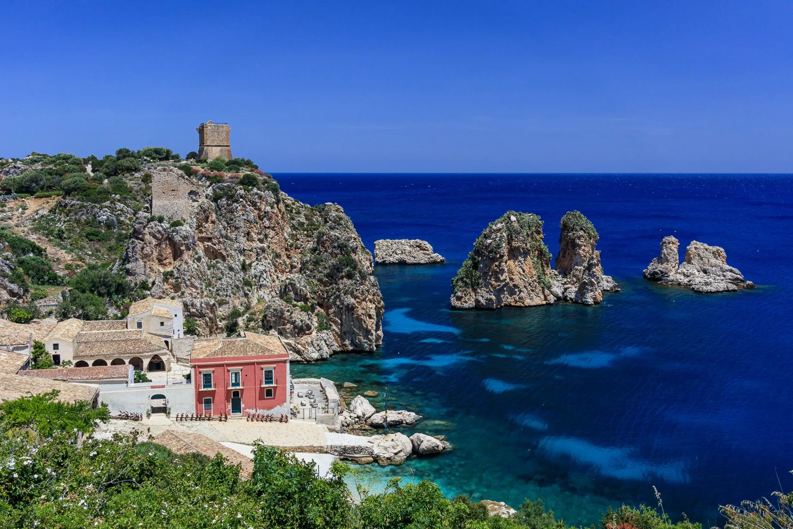 La tonnara di Scopello con i faraglioni e la torre di avvistamento sul mare blu